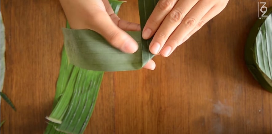 Fold the leaf diagonally to form a triangular shape