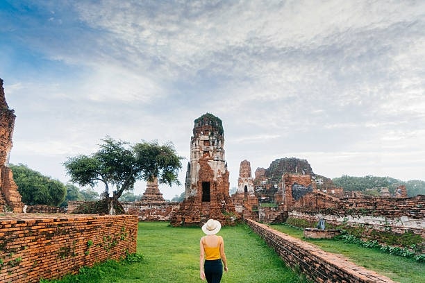 Woman walking near ancient Buddhist Temple